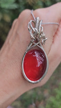 Load and play video in Gallery viewer, Rare Ruby-Red Coloured Amber Pendant set in Sterling Silver
